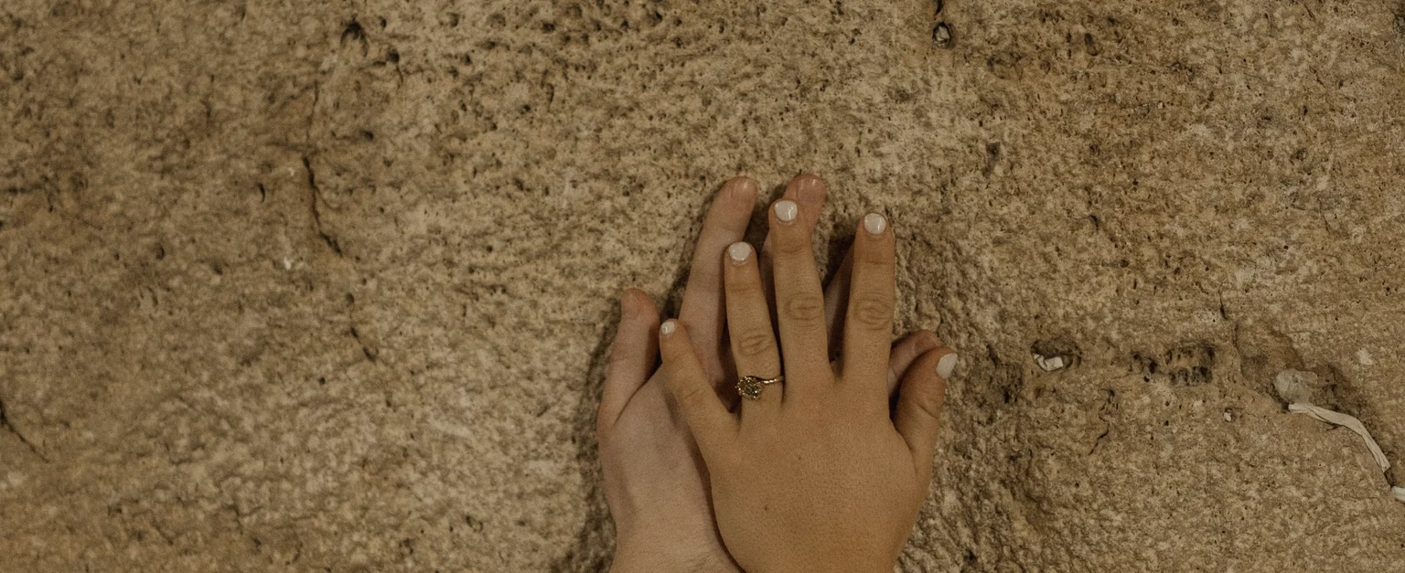 Our hands resting together on the stones of the Western Wall in Jerusalem.
