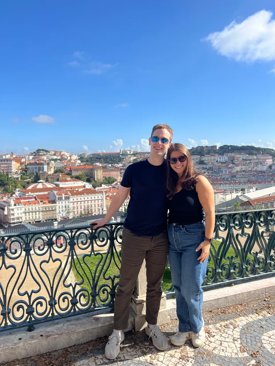 Leah and Justin in sunglasses at a Lisbon overlook, days before the proposal.