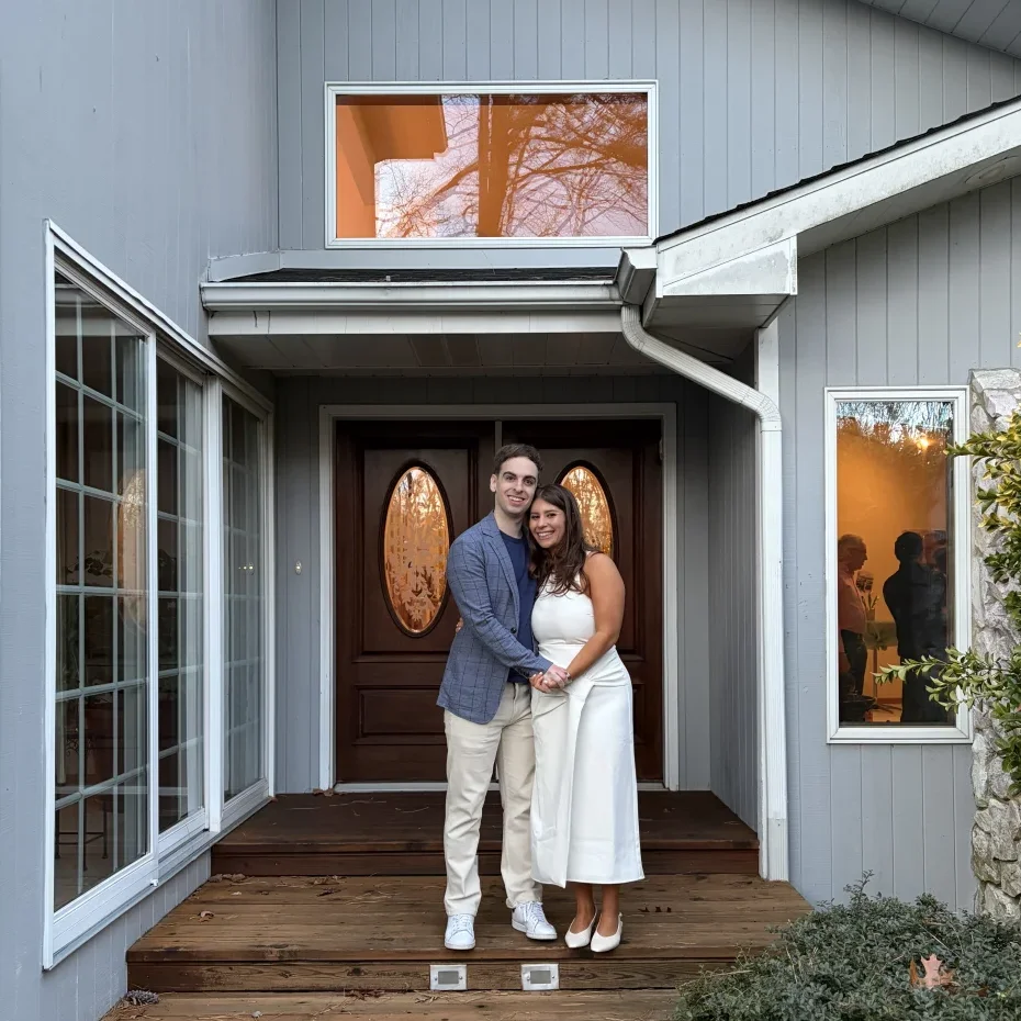 Leah and Justin standing together on the front steps of their first home in Voorhees, New Jersey.
