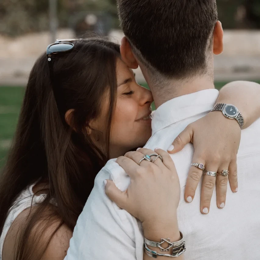 Leah and Justin embracing in Jerusalem, her engagement ring resting on his shoulder.